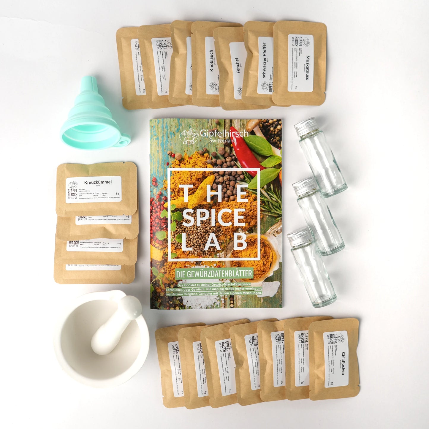 The Spice Lab contents with spice packets, a mortar and pestle, and a funnel on a white background.