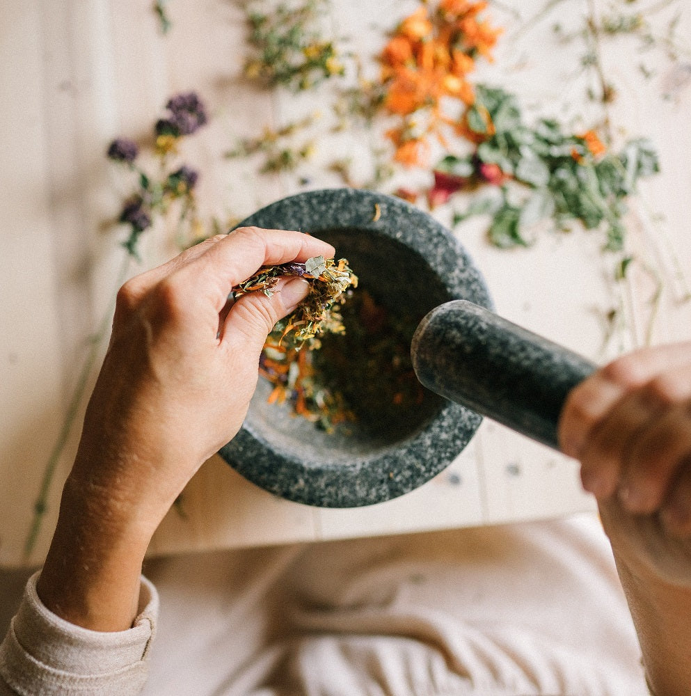 a person using a pestle and mortar, mixing Gipfelhirsch spices